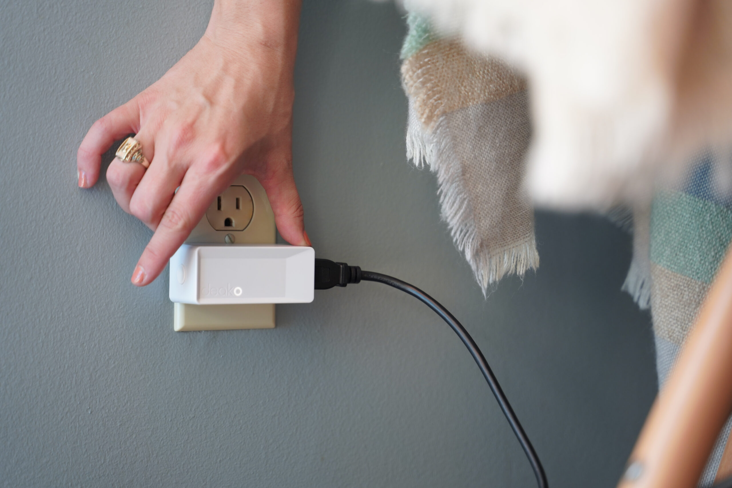 Deako Smart Plug being turned into a wall.