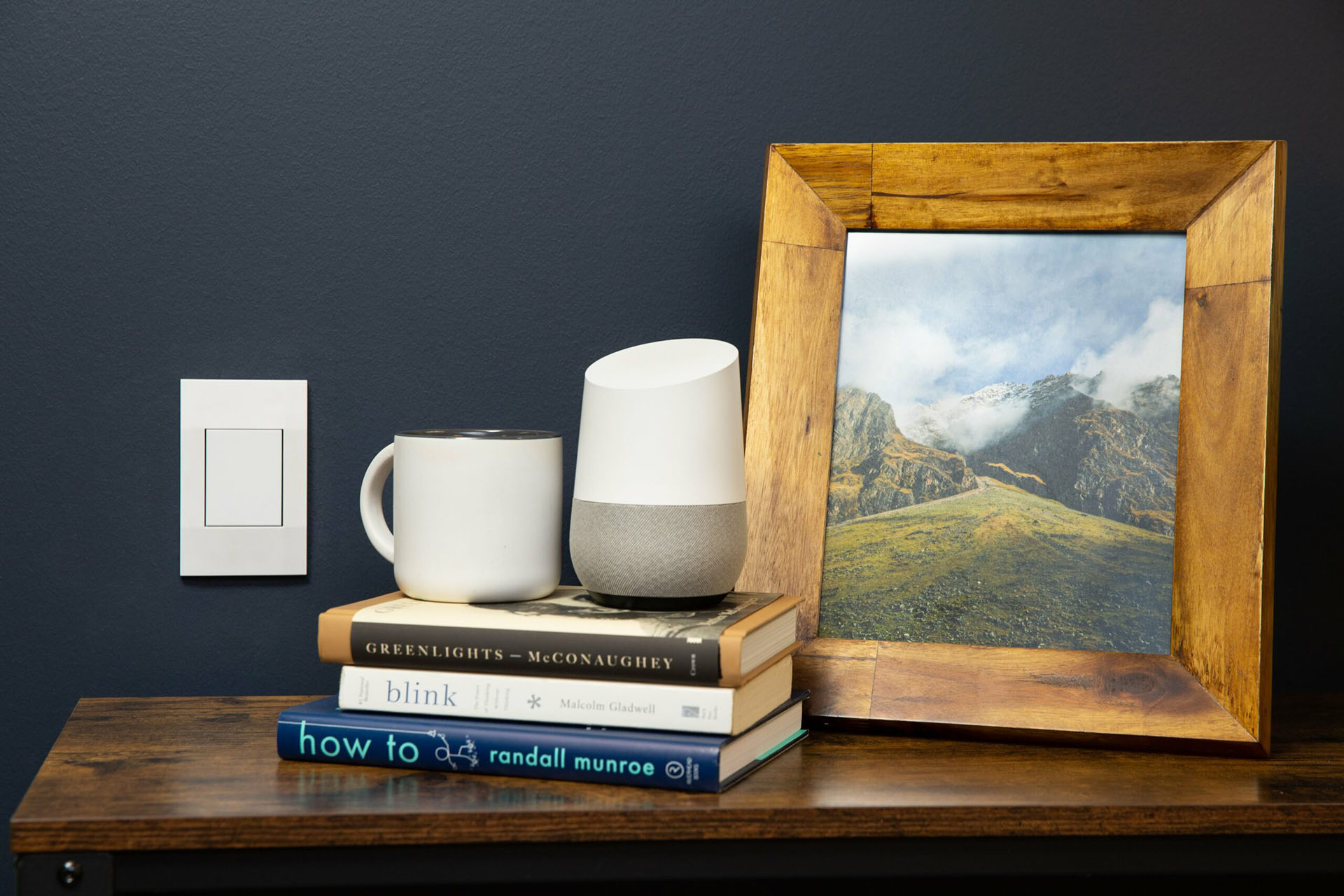 The Deako Smart Dimmer next to a photograph.